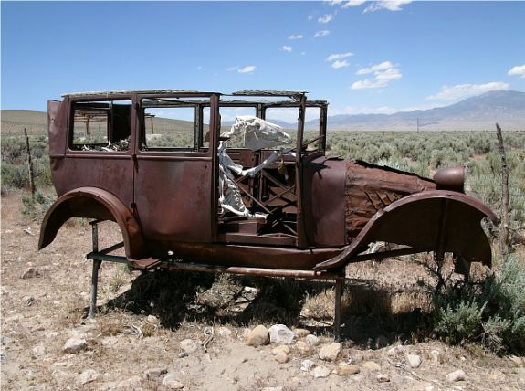 Old car sitting out in the desert.