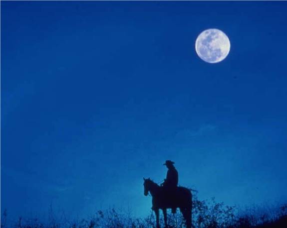 Riding horseback under a full moon
