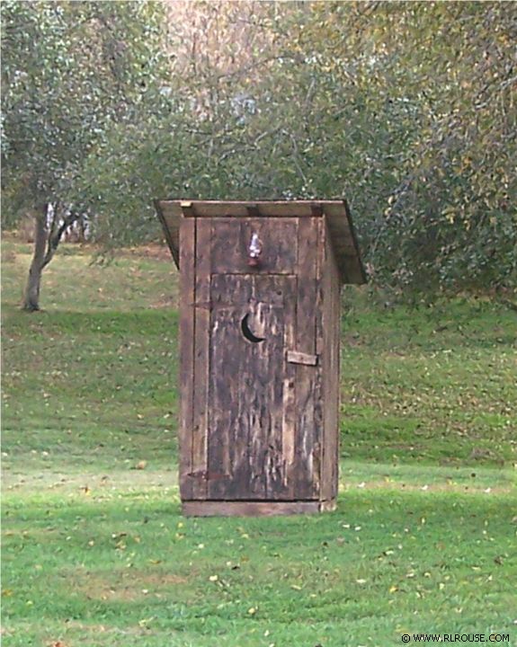 A faded old outhouse.