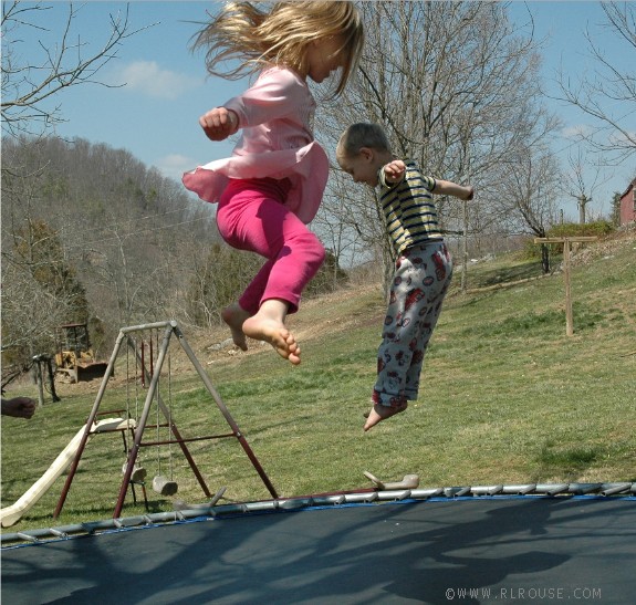 Kids jumping on a trampoline.